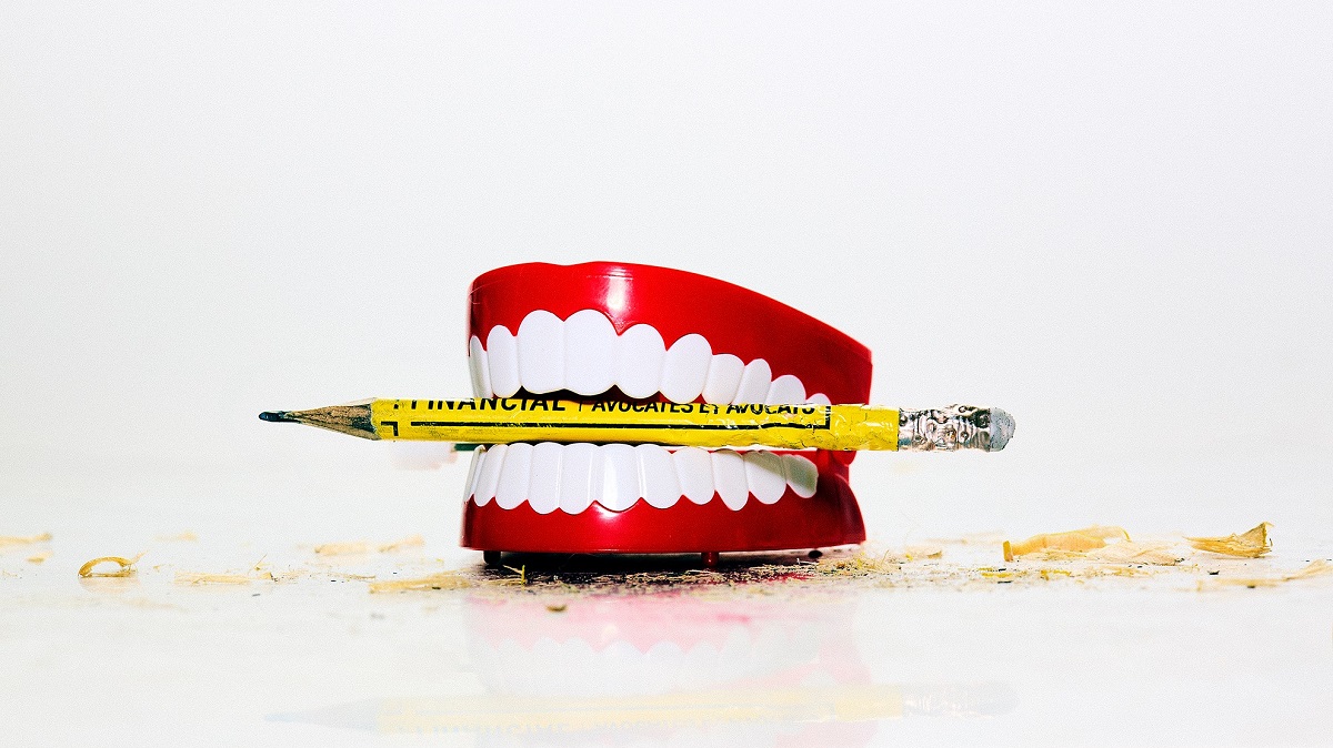 Un dentier avec un crayon jaune coincé entre les dents