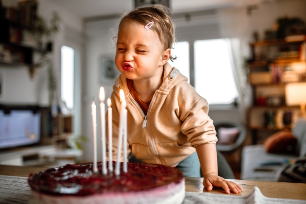 Toddler blowing birthday candles