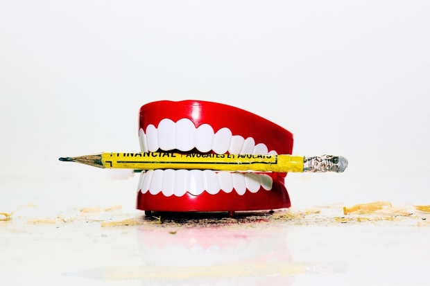 Dentiers avec un crayon jaune entre les dents